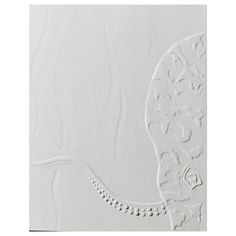 a white wall with an intricate design in the center and bottom part of it's face