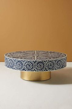 a blue and white plate sitting on top of a table next to a brown wall