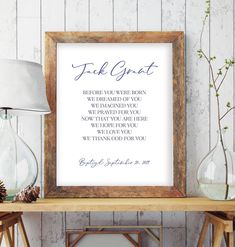 a wooden frame with a poem on it next to a lamp and some glass vases