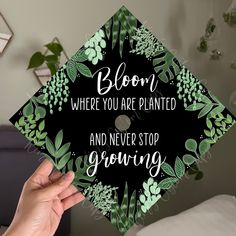 someone holding up a graduation cap that says bloom where you are planted and never stop growing