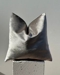 a silver pillow sitting on top of a cement block