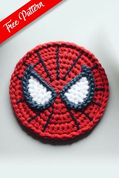 a crocheted spiderman brooch sits on a table