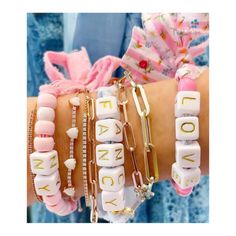 several bracelets with words on them are shown in different colors and styles, including pink