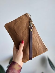 "This medium size waxed canvas wristlet is a great size for your keys, phone, cardcase and other daily essentials. A perfect pouch for grab and go on a busy day. It can be used as an organizer for your big bag or travel pouch to carry foreign currencies and passport. It also makes a great gift for him/her.   your Details  Wristlet pouch is made with 12 oz waxed cotton canvas, anti-brass zipper, matching lining. Strap is made with genuine leather and it is removable.  Size:  5.5\"x9\", fits any phone sizes and have additional room for other stuffs.  Care: Spot clean with damp rag. Gentle use of castile soap as needed. Do not wash, do not dry clean do not tumble dry or iron. Re-waxed as needed Here more similar style we offer in our shop  https://etsy.me/3bDte6c" Brown Wristlet With Zipper Pouch For Gift, Brown Wristlet With Zipper Pouch As Gift, Brown Wristlet With Cell Phone Pocket For Everyday, Brown Everyday Wristlet With Cell Phone Pocket, Everyday Brown Wristlet With Cell Phone Pocket, Everyday Brown Wristlet With Zipper Pouch, Green Clutch Bag, Green Clutch, Pouch With Zipper