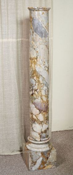 a marble column stands in front of a curtain