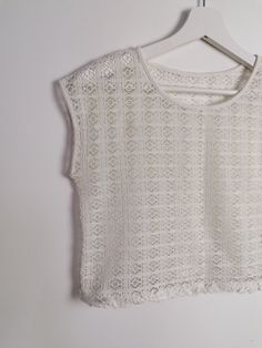 Beautiful off-white sheer crochet knit crop top, fringed hem/ Excellent vintage condition. Would fit size XS. Model wears size 8-10 UK, S-M US, is 160 cm tall and weighs 54 kg. All of our items are freshly laundered with quality detergents and fabric softeners, absolutely ready to wear the moment you receive them! Keep in mind, this item is vintage and subtle signs of passing time may be present, adding to its character and making it even more worthy of your love. For more info, additional photo Cream Open Knit Lace Tops, Cream Lace Open Knit Top, Cream Lace Top With Open Knit, Short Sleeve Open Knit Crochet Top, White Open Knit Lace Top, White Bohemian Knit Top With Crochet Lace, Bohemian Cropped Lace Crochet Top, Cropped Lace Crochet Top, White Lace Tops With Pointelle Knit