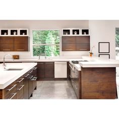 a kitchen with white counter tops and wooden cabinets