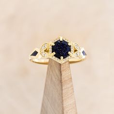 Ring Style: The "Lucy in the Sky" petite is a halo-style blue goldstone women's engagement ring with diamond accents and goldstone inlays Center Stone: 6.5mm Round Cut Blue Goldstone Accent Stones: 1/8ctw (18) 0.8mm Round Diamonds (8) 1.3mm Round Diamonds Available In: 14K White Gold, 14K Yellow Gold, or 14K Rose Gold Customizable: Because each ring is handcrafted to order we can customize center or accent stones, use unique materials, customize design features, or even use your own personal mat Staghead Designs, Agate Engagement Ring, Lucy In The Sky, Blue Goldstone, Halo Style, Mens Engagement, Ring With Diamond, Detailed Ring, Custom Ring Designs