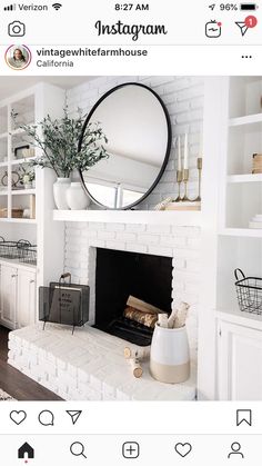 a white fireplace with a round mirror above it