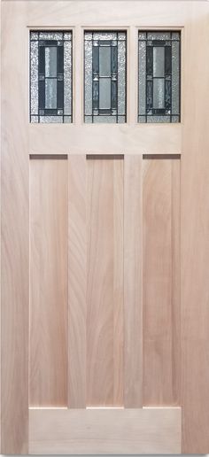 a wooden door with three glass panels on the top and bottom panel, in front of a white wall