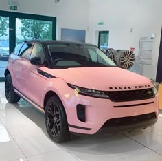 a pink range rover parked in a showroom