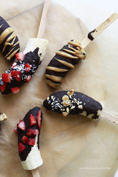 chocolate covered strawberries and bananas on sticks with peanut butter drizzled over them