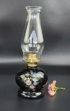 Vintage Oil Lamp - Black Base - Floral Design - 14 1/4" Tall This is Pre-Owned and is as Good as New. No Chips or Cracks. Has no wicker. This is a beautiful oil lamp that has beautiful shape base for oil and a glass chimney. Perfect to add that vintage vibes to your home decor.  Dimensions (approx.) -  Base - 5.5" across, 7.5" tall w/o chimney Chimney - 8 3/4" tall Overall - 14 1/4" Tall and weighs 2.50 lb. Oil Lamp Flower Vase, Mineral Oil Lamps, Mineral Oil Lamp, Mini Oil Lamps Vintage, Vintage Oil Lamp, Oil Lamps Antique Blue, Oil Lamp, Black Lamps, Oil Lamps