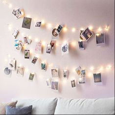 a white couch sitting next to a wall with pictures hanging on it's side