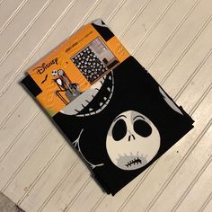 a black and white halloween themed piece of cloth with a skeleton on it's face