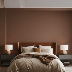 a bed with two lamps on either side of it and a brown wall in the background