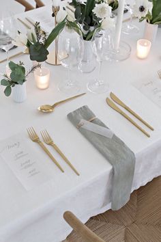 a table set with place settings and candles