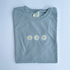 "Retro Daisy Embroidered T Shirt - Comfort Colors Unisex Flowers Shirt - Gift For Her - Shirt Info - -Comfort Colors 1717 Tee in Granite -6.1 oz., 100% ring spun USA cotton -Preshrunk, soft-washed, garment-dyed fabric -Made with sustainably and fairly grown USA cotton and sewn with USA cotton thread -Twill taped shoulder-to-shoulder -Set-in sleeves -Double-needle stitched sleeves and bottom hem -1\" ribbed collar with double-needle topstitched neckline -Comfort colors uses 50% less water than traditional pigment dye processes on pigment dye and color blast garments -Comfort colors®, through Gildan's community investment program, supports education, the environment, humanitarian aid and active living in the communities we do business in Care instructions: -Machine cold wash, inside out, wit White Crew Neck T-shirt With Floral Applique, Casual Long Sleeve T-shirt With Floral Embroidery, Embroidered Long Sleeve T-shirt For Summer, White Short Sleeve T-shirt With Floral Applique, Basic Cotton Tops With Custom Embroidery And Relaxed Fit, Basic Relaxed Fit Top With Custom Embroidery, Blue Floral Embroidered Short Sleeve T-shirt, White Floral Applique Crew Neck T-shirt, Blue T-shirt With Embroidered Text For Spring