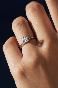 a woman's hand with a diamond ring on it