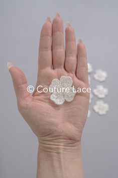 a person's hand with a flower brooch in the middle of their palm