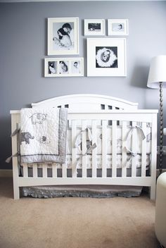 a white crib with pictures on the wall