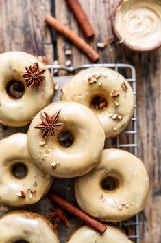 glazed doughnuts with cinnamon and anise on a cooling rack, surrounded by cinnamon sticks