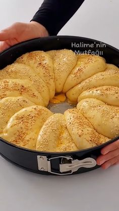 a person holding a pan filled with bread