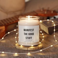 a candle sitting on top of a table next to a string of lights and a guitar