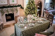 a christmas tree is lit in the living room and dining room with green table cloths