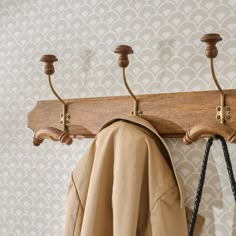 a coat rack with three coats hanging from it's hooks and two coats on the hangers