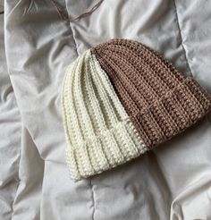 a crocheted hat laying on top of a bed