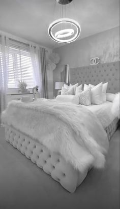 a large white bed sitting in a bedroom next to a window