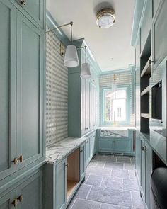 an empty kitchen with blue cabinets and tile flooring on the walls, along with marble counter tops