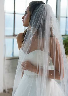 a woman in a white wedding dress and veil