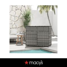 a wicker sideboard next to a pool with a palm tree in the background