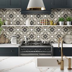 a kitchen with blue cabinets and white counter tops, gold accents on the backsplash