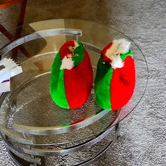 two santa hats sitting on top of a glass table