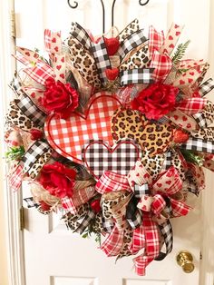 a heart shaped wreath with leopard print and red flowers on the front door for valentine's day