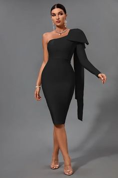 a woman wearing a black dress with an asymmetrical neckline