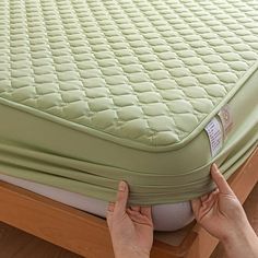 the mattress is being held up by two hands