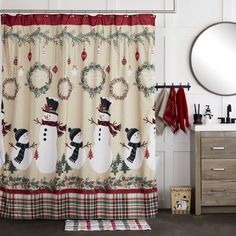 a bathroom decorated for christmas with snowmen and wreaths on the shower curtain valance