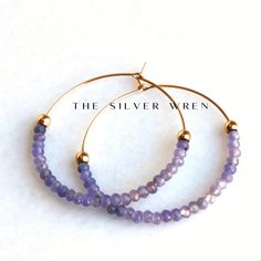 Tanzanite Gold Hoop Earrings D E T A I L S These gorgeous hoop earrings are created with Genuine Natural Tanzanite 3mm beads and 14kt gold filled accents   Beaded by hand  14kt gold filled 35mm hoops  ∙ EXTRA LOVE ∙ Crafted and curated just for you in the desert of our Arizona studio. All of our jewelry comes gift packaged!  We are happy to leave a note if this is a special gift, just let us know in the message box at checkout.  PRODUCTION ∙ TIMES All items are made to order. Please check the to Faceted Hoop Earrings As Gift, Faceted Hoop Jewelry For Gifts, Purple Hoop Earrings As Gift, Jewelry Hoop Earrings, Earrings Gold Hoop, Tanzanite Jewelry, Tanzanite Earrings, Gift Best Friend, Hoop Earrings Gold