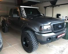 a truck parked in a garage next to two other trucks