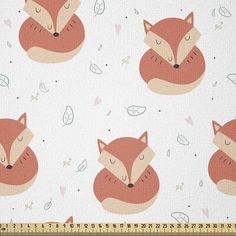 a fabric with foxes on it and leaves in the background, as well as a ruler