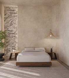 a bed sitting in the middle of a bedroom next to a wall with a plant on it