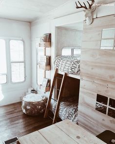 a bunk bed in a small room with wooden floors and walls, next to a window