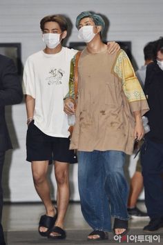 two young men wearing face masks while standing next to each other