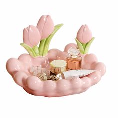 a pink flower shaped container with cosmetics and flowers in it's centerpieces