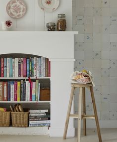 a white fireplace with bookshelves and baskets on the top shelf next to it