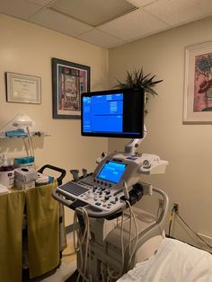 a hospital room with medical equipment and pictures on the wall, including a computer monitor